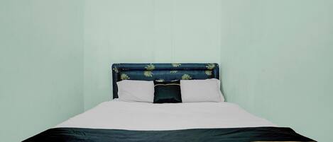 A bed with a headboard, two pillows, and a bedspread.