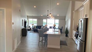 Een ruime keuken met een centraal eiland, moderne apparatuur en uitzicht naar buiten.