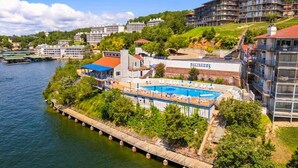 Un hôtel situé au bord de l’eau, doté d’une piscine, d’un quai et offrant une vue sur les bâtiments environnants.