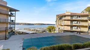 Une piscine sur le toit offrant une vue sur un port de plaisance et des immeubles.