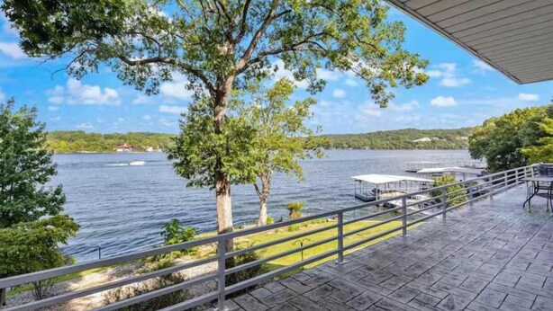 Una proprietà sul lungolago con una terrazza, una ringhiera e vista sul lago.