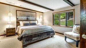 A bedroom with a large bed, bedside lamps, a window, and a chair. - Rustic 3BR Lake House - LAKE VIEW - Lake Ozark (Lake Ozark)