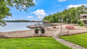A lakeside property with a dock, chairs, and a picnic table. - Rustic 3BR Lake House - LAKE VIEW - Lake Ozark (Lake Ozark)