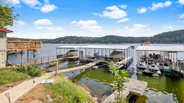 Un muelle con varios amaraderos, un área cubierta y un edificio con terraza.