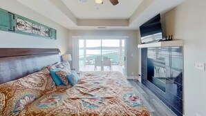 Une chambre avec un grand lit, une télévision et un balcon offrant une vue agréable.