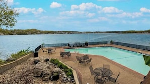 Una piscina con area relax all'aperto e vista sull'acqua.