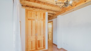 A hallway with wooden doors, a tiled floor, and a ceiling with exposed beams. - Holiday Home 'Romo 1' with Mountain View (Chavida)