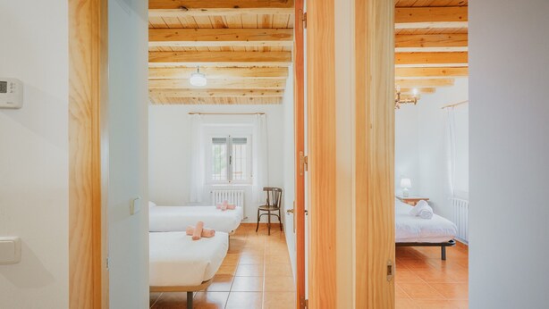 A room with two beds, a chair, a radiator, and a window. - Holiday Home 'Romo 1' with Mountain View (Chavida)