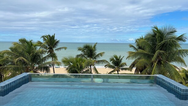 Ein Pool mit Blick auf Strand und Meer.