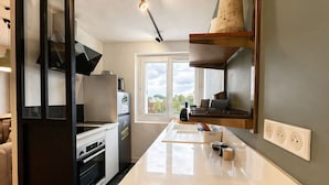 Una cocina moderna con una isla central, electrodomésticos integrados y un ventanal con vistas.