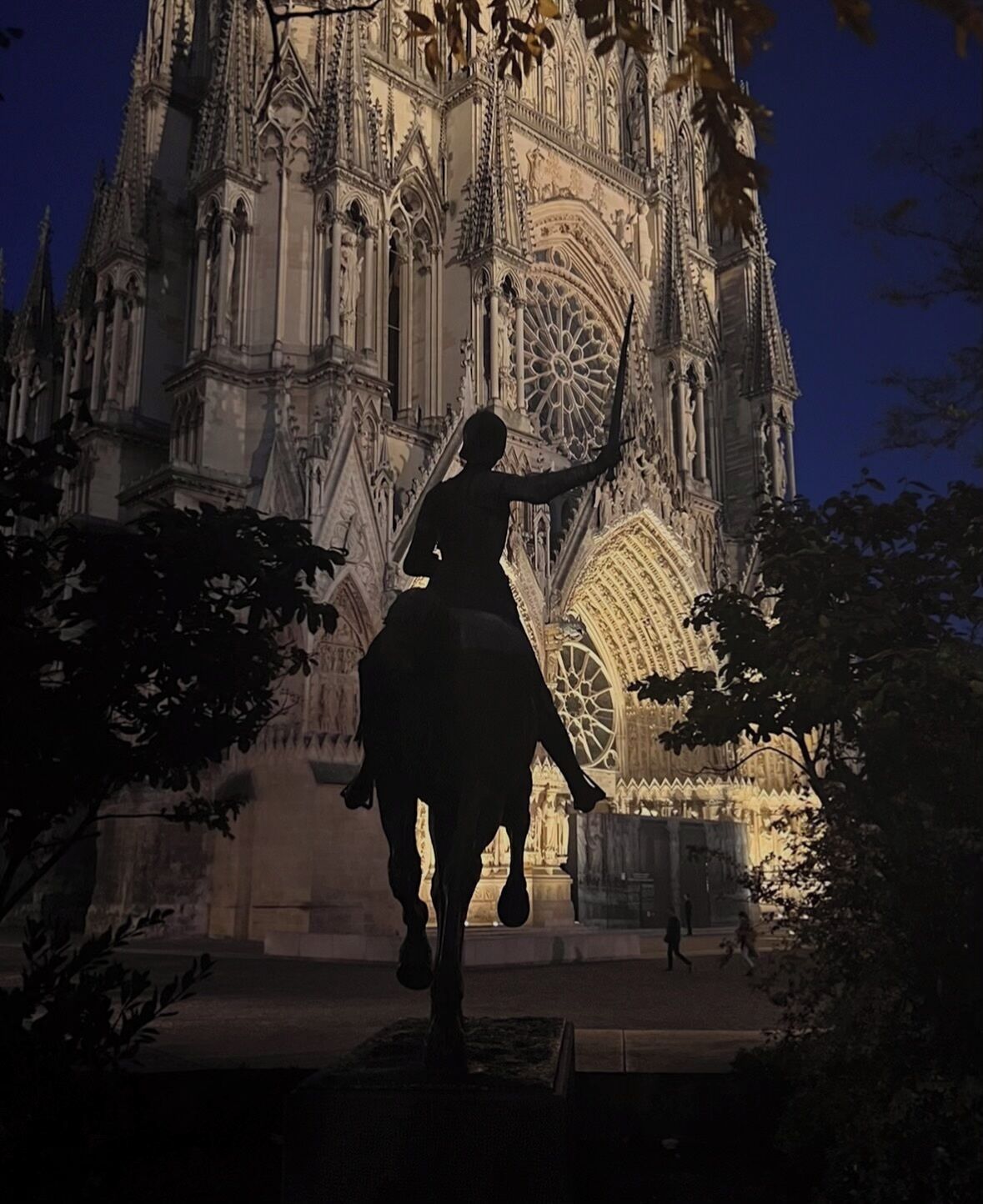 Eine Silhouette einer Person zu Pferd vor einem Dom mit aufwendiger Architektur.