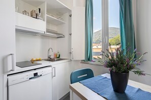 A compact kitchen with a dishwasher, a sink, and a window with curtains. - Apartment 'Bilocale - Lavanda e Salvia' with Wi-Fi and Air Conditioning (La Spezia)