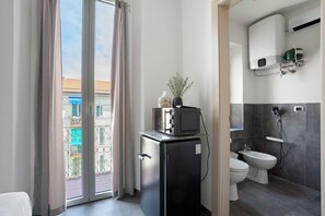 A compact bathroom with a toilet, bidet, and a water heater. - Room - Rosmarino with Balcony, Wi-Fi and Air Conditioning (La Spezia)