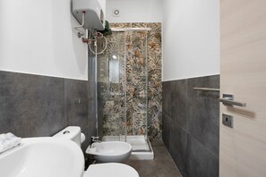 A bathroom with a toilet, bidet, and shower. - Studio Apartment 'Monolocale - Timo' with Wi-Fi and Air Conditioning (La Spezia)