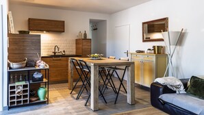 Ett kompakt bostadsutrymme med kök, matplats och sittgrupp.
