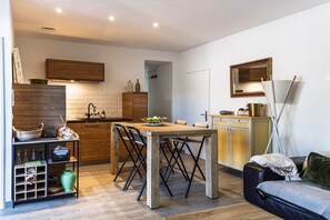 A compact living space with a kitchen, dining area, and seating area. - L'Océan - Au calme de la Campagne (Saint-Martin-de-Hinx)