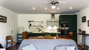 Une cuisine moderne dotée d’un îlot central, d’appareils électroménagers intégrés et d’un ventilateur de plafond.