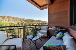 A balcony with a view of mountains, a grill, and seating. - Lux Beaver Creek Escape | Views & Resort Amenities (Avon)