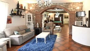 Una sala de estar con sofá, mesa de centro y mesa de billar.