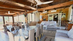 Amplia sala de estar con una mesa redonda de mármol, un sofá y un televisor.