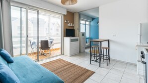 Eine moderne Wohnung mit Balkon, einer Küchenzeile, einem Essbereich und einem Wohnzimmer.