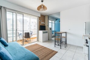A modern apartment with a balcony, a kitchenette, a dining area, and a living room. - Studio Côte de Nacre - À 450 m de la Plage (Courseulles-sur-Mer)