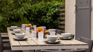 A dining table set with bowls, glasses, and a fruit bowl. - Villa Veronica - À 50 m de la plage (Lège-Cap-Ferret)