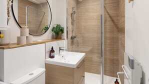 A modern bathroom with a shower, sink, and toilet. - Le Winston - Bel appartement proche de la plage (Dinard)