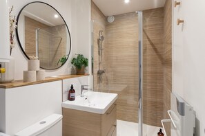 Ein modernes Badezimmer mit Dusche, Waschbecken und Toilette.