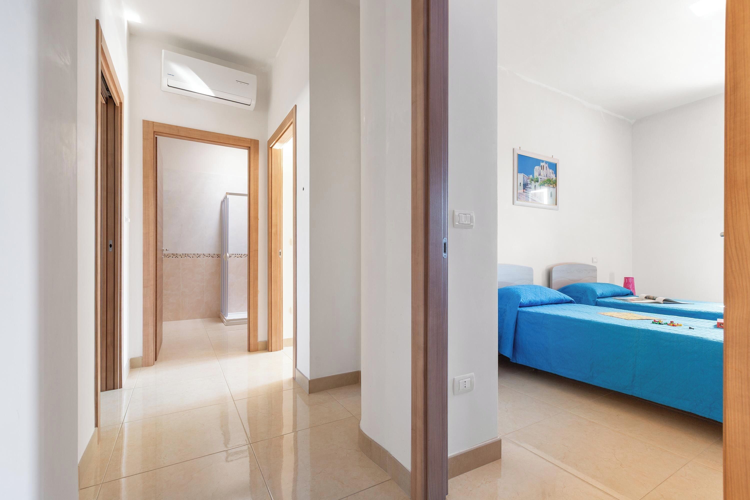 Ein Hotelzimmer mit Bett, Badezimmer und einem Gang zu einem weiteren Zimmer.