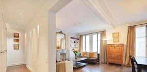 Una sala de estar con chimenea, sofá y estanterías.