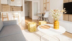 Een moderne woonkamer met een bank, een ronde salontafel en een eetgedeelte met stoelen en een tafel.