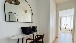 Een moderne kamer met een bureau, stoel en garderobe.