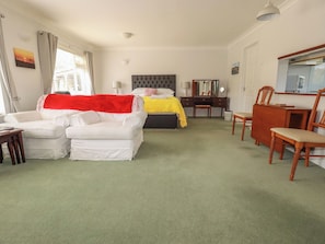 Habitación de hotel con cama, sofá, escritorio y silla.