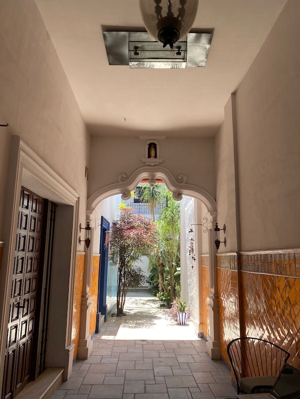 Ein Korridor mit Deckenventilator, einer Tür und einem kleinen Schrein.