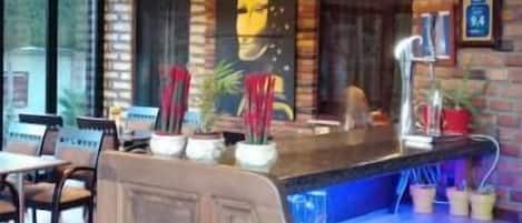 A restaurant with a brick wall, wooden counter, and tiled floor.