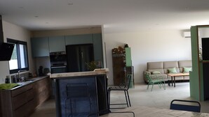 Un espace de vie moderne comprenant une cuisine, un coin repas et un espace détente.