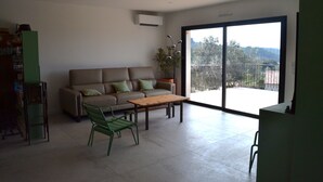 Un salon moderne avec un canapé, une table basse et un fauteuil vert.