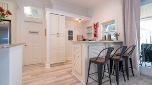 A kitchen with a bar area, a sign for 'Laundry,' and a coffee machine.