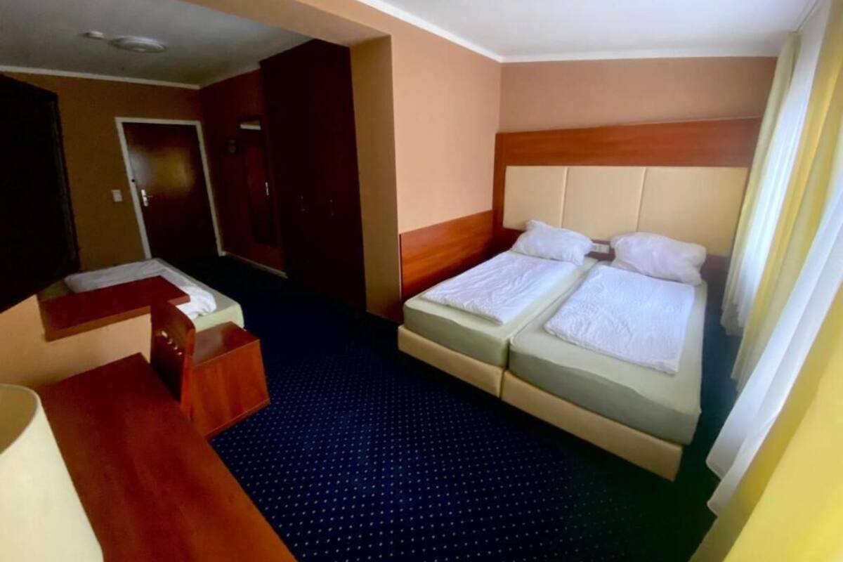 A hotel room with a bed, a desk, and a chair.