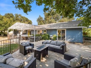 A covered patio area with outdoor furniture, a grill, and a pool table. - Meadowlark Retreat Near Yosemite Private (Ahwahnee)