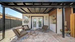 A covered patio with a seating area, a small table, and a patterned rug. - 1BR Casita, Central Location + Private Bkyd + Free Uber Airport Pickup (Las Vegas)