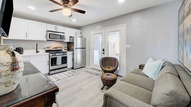 A modern kitchen with white cabinets, stainless steel appliances, and a ceiling fan. - 1BR Casita, Central Location + Private Bkyd + Free Uber Airport Pickup (Las Vegas)