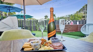 Ein Tisch mit einer Flasche Monetto Champagner, einem Champagnerglas und einer Platte mit Snacks.