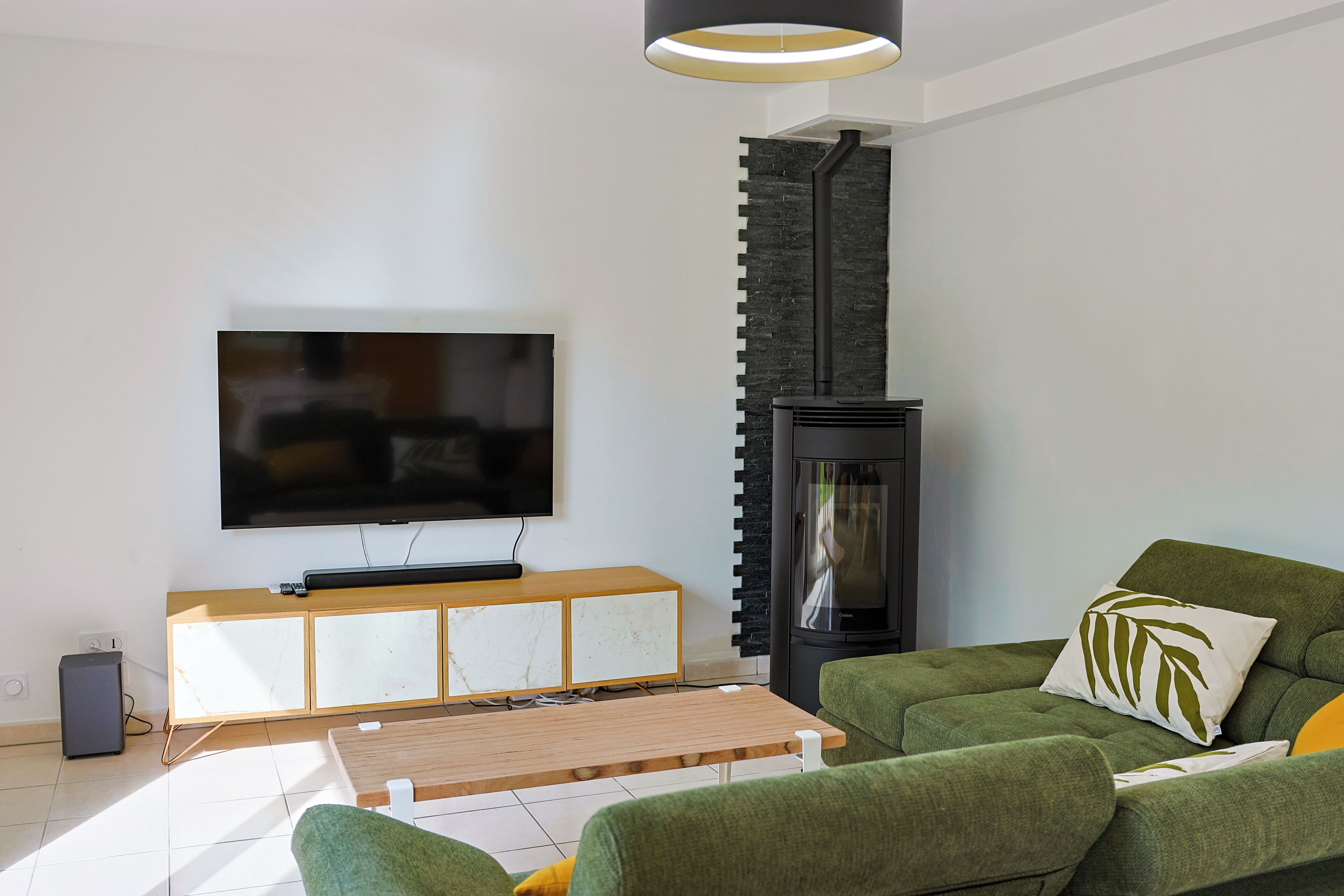 A living room with a flat-screen TV, a fireplace, a sofa, and a coffee table.