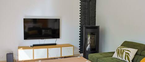 A living room with a flat-screen TV, a fireplace, a sofa, and a coffee table.