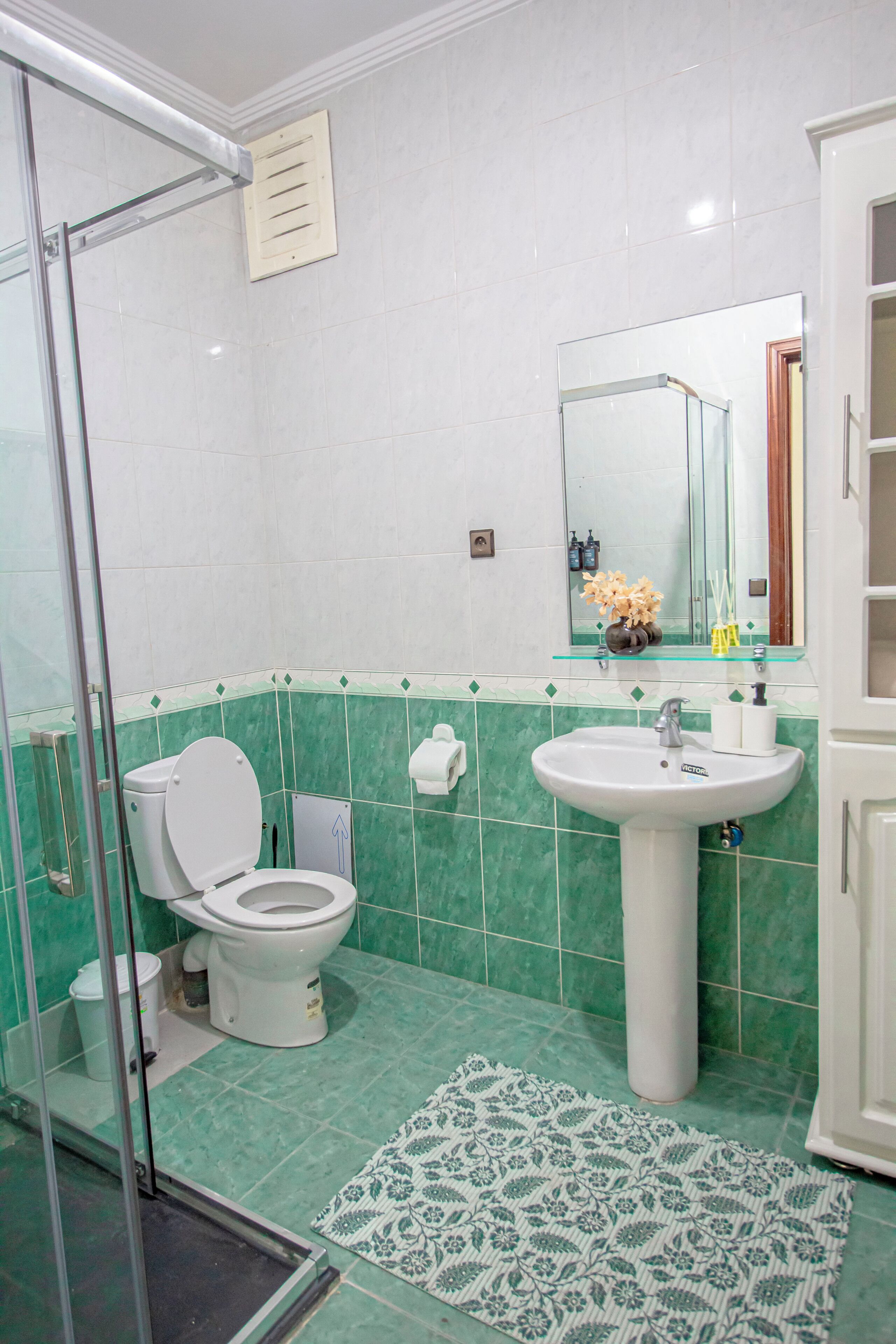 Un baño con inodoro, lavamanos y ducha.