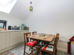 Un comedor con mesa de madera, sillas y una lámpara colgante.