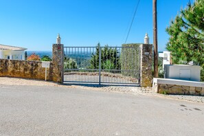 A gated property with stone walls, a metal gate, and a view of the landscape. - Villa Montinho da Serra, Monchique (Monchique)