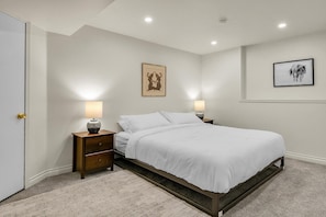 A bedroom with a bed, two bedside tables, a door, and two wall-mounted lamps. - 2-bedroom apartment in peaceful Seattle neighborhood near beach and downtown (Seattle)